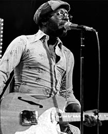 Curtis Mayfield playing guitar and singing