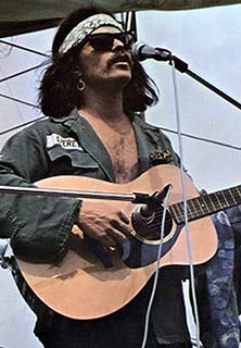 Country Joe McDonald playing at woodstock 1969